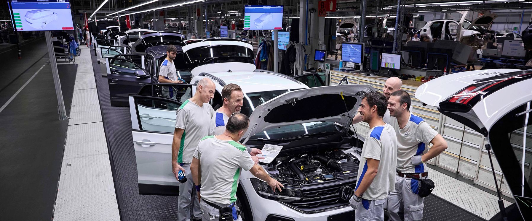 4 men chatting at an opened bonnet car