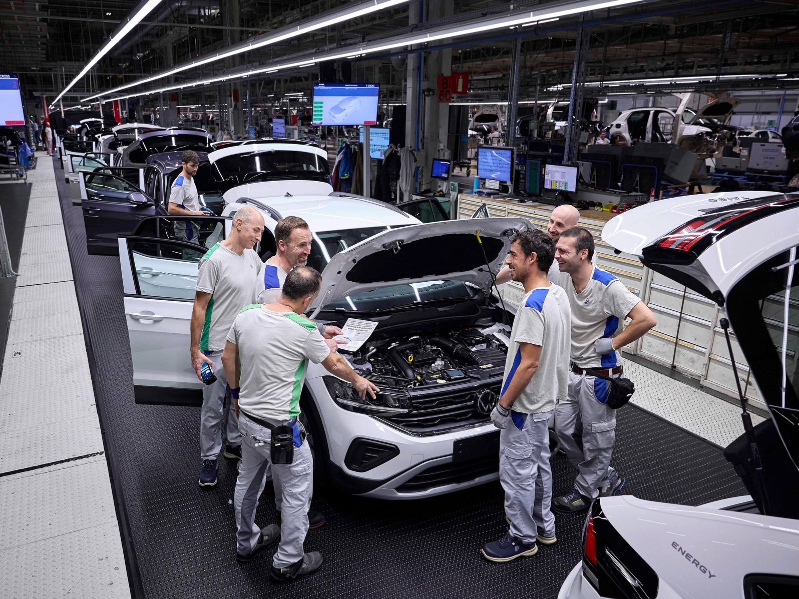 4 men chatting at an opened bonnet car