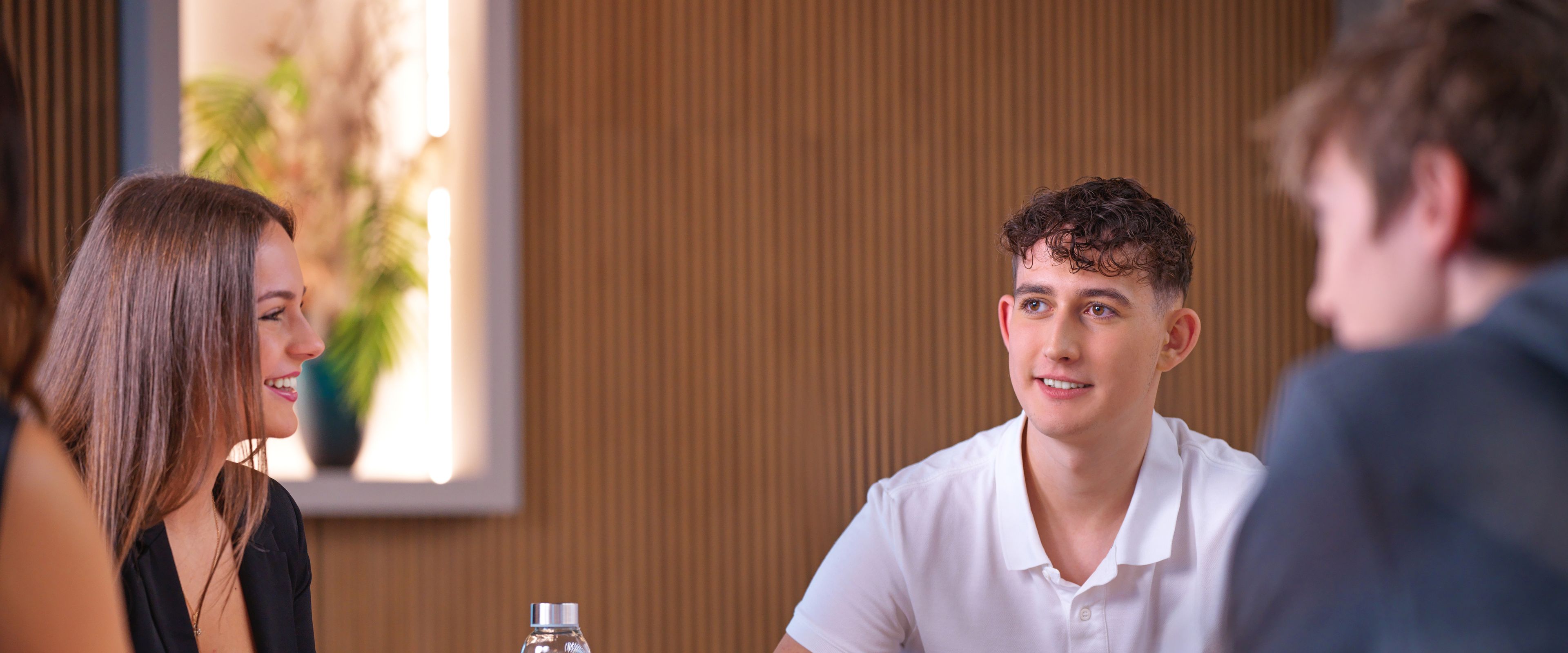 Fiatalok ülnek egy asztal körül.