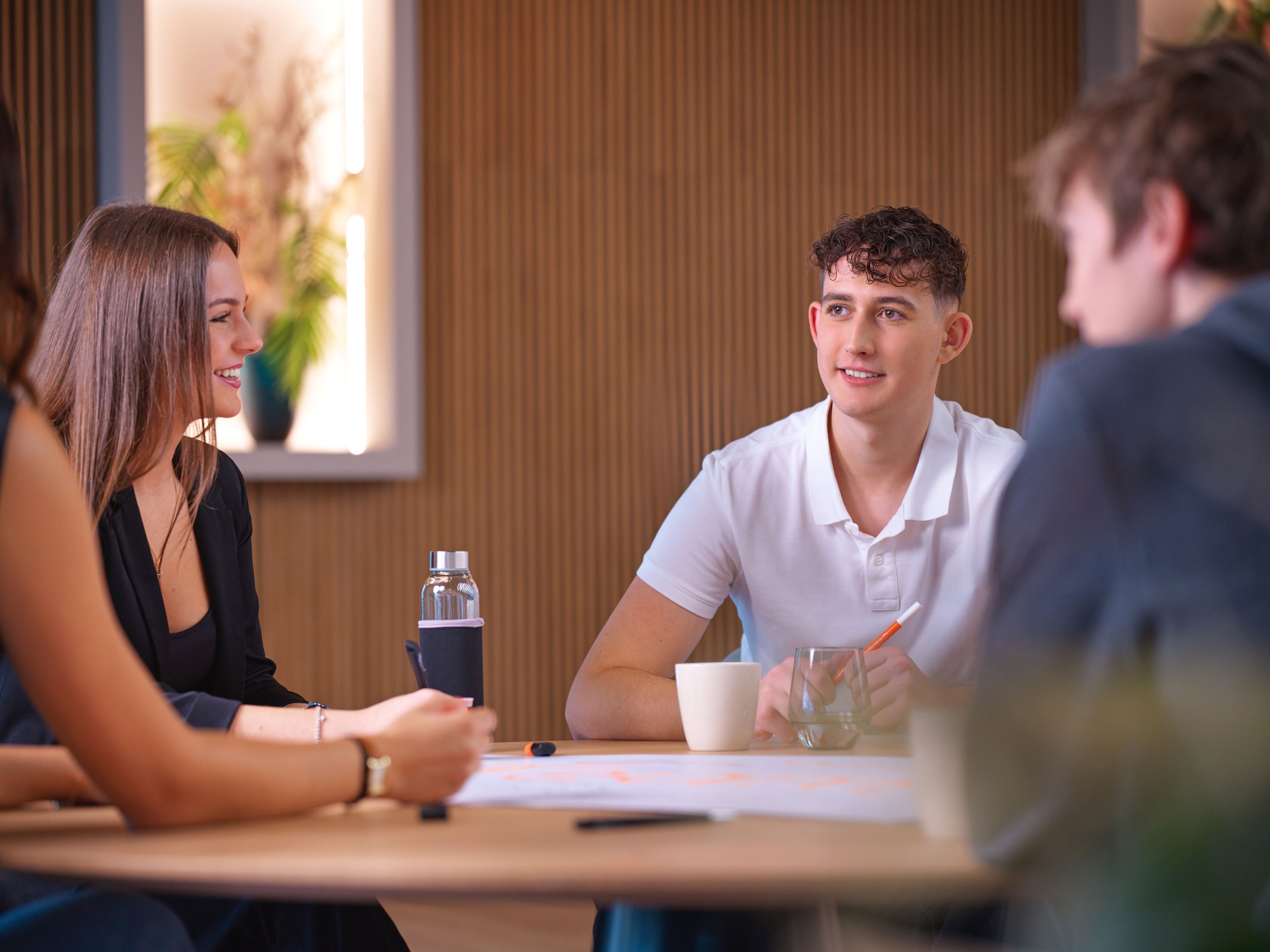 Fiatalok ülnek egy asztal körül.