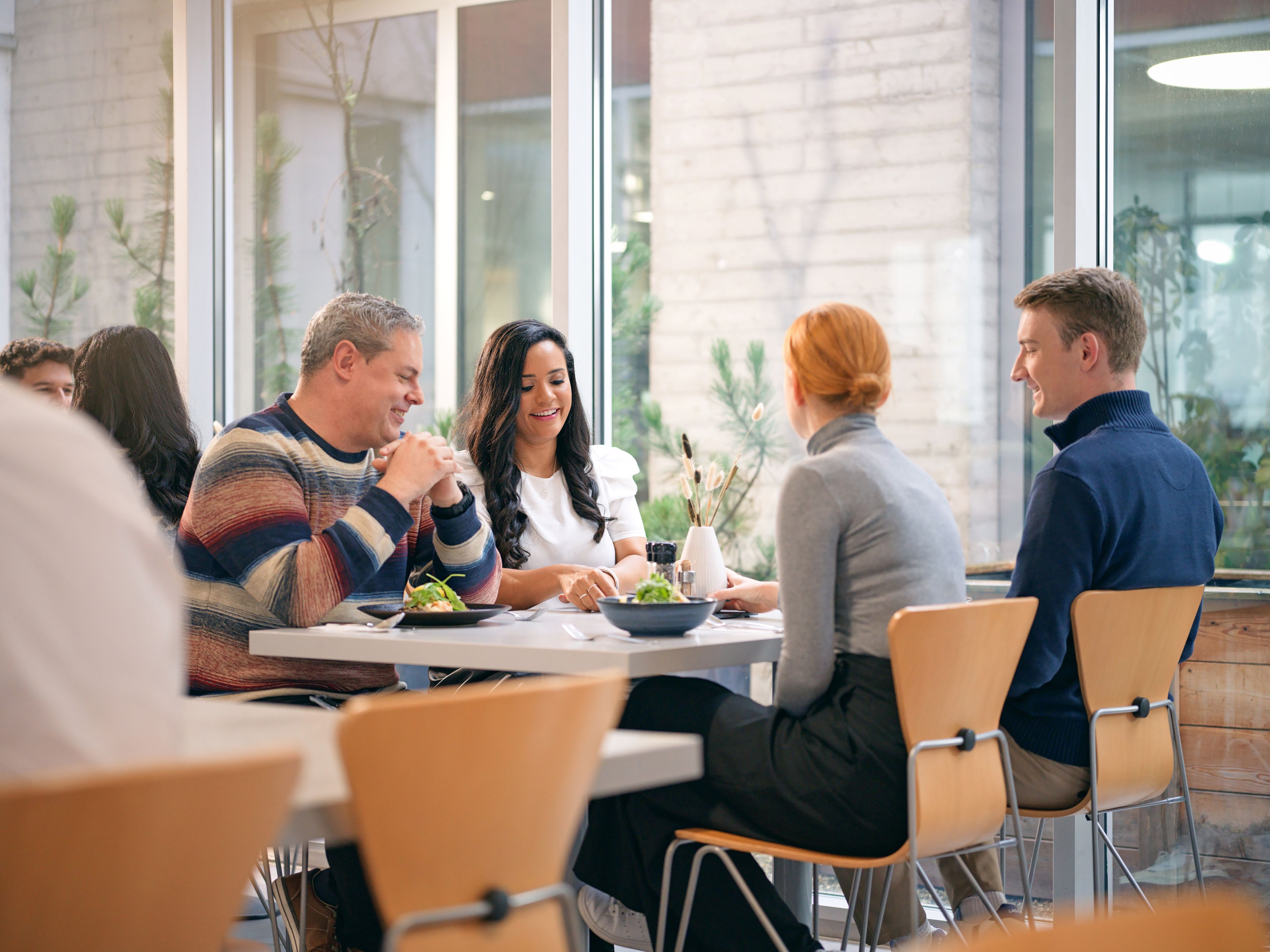 Four people are talking and eating in a restaurant.