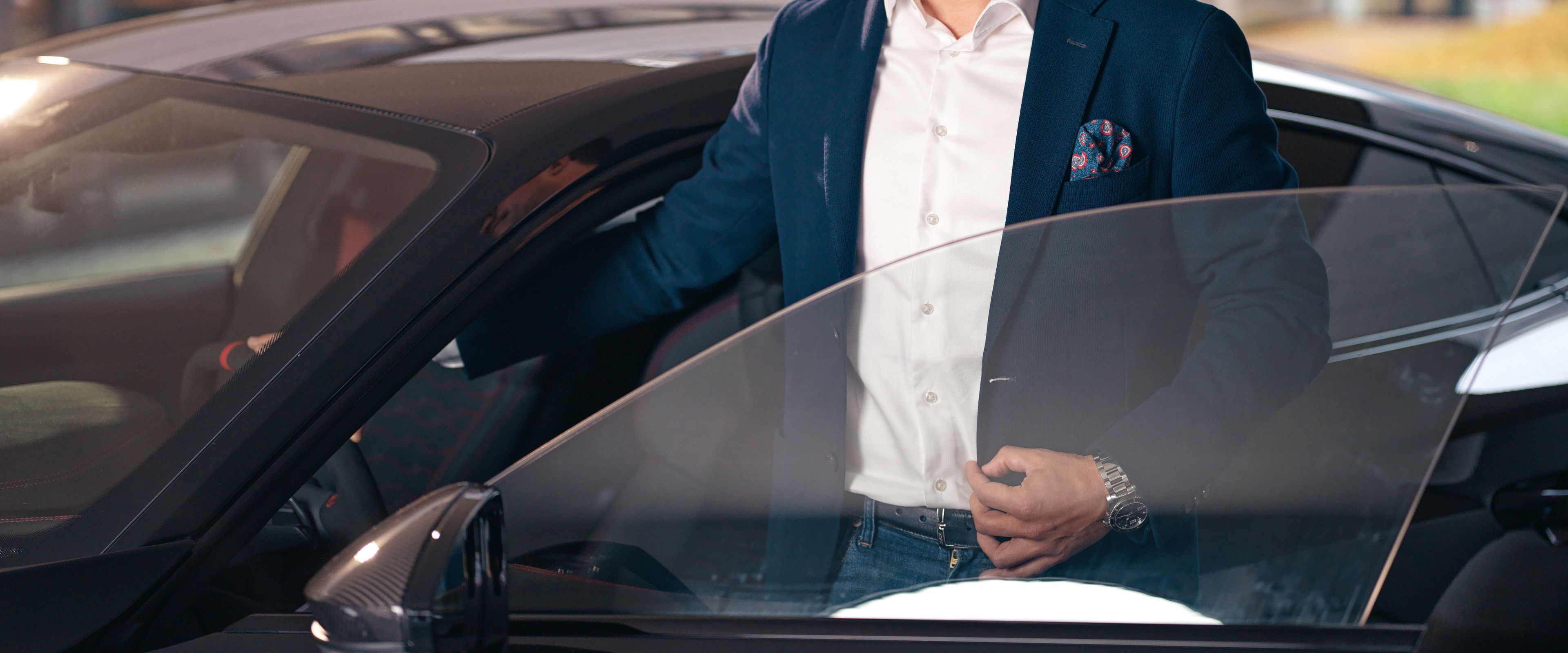 Egy férfi éppen kiszáll egy fekete autóból.