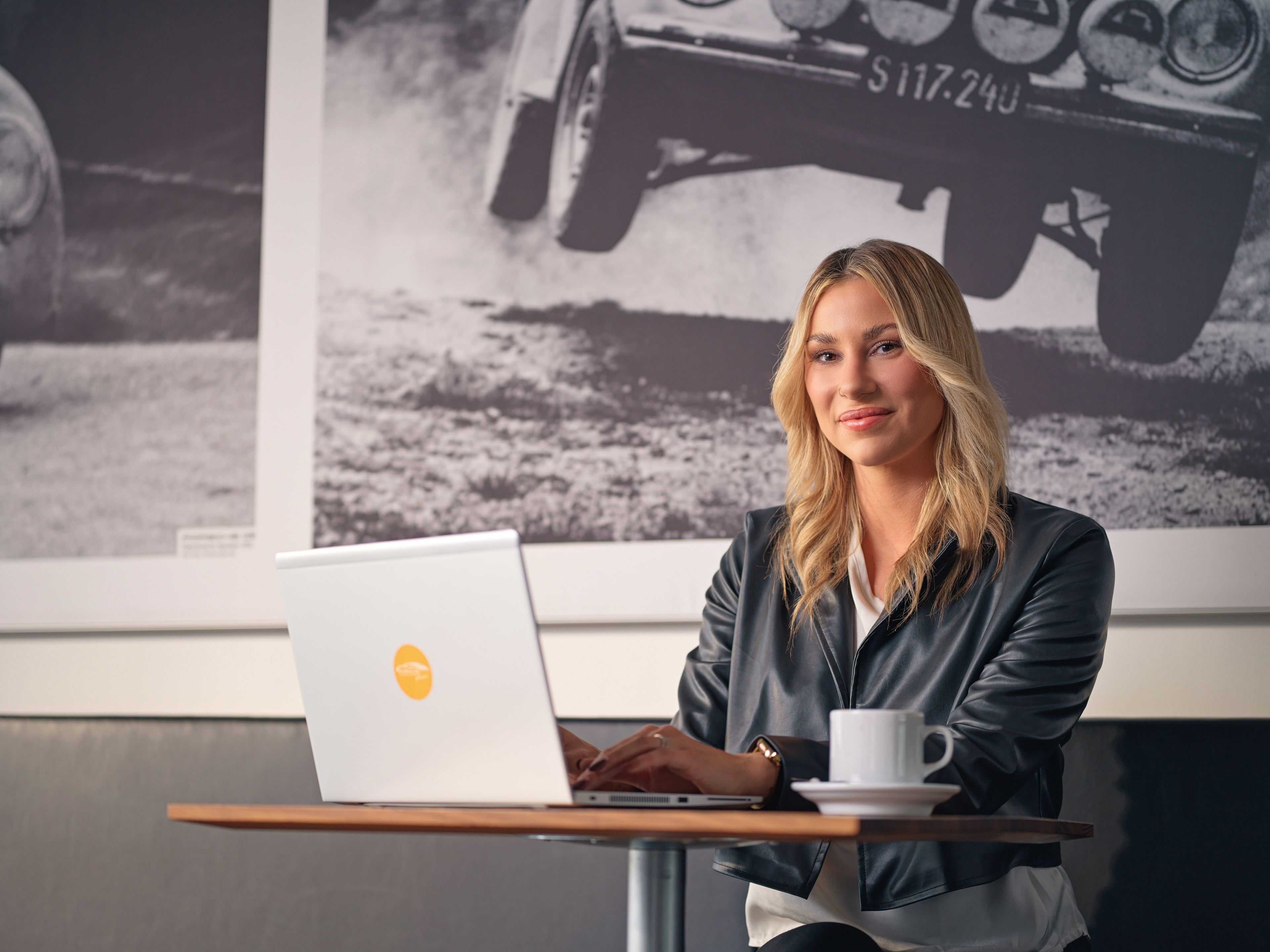 A young lady in a café works on a laptop.