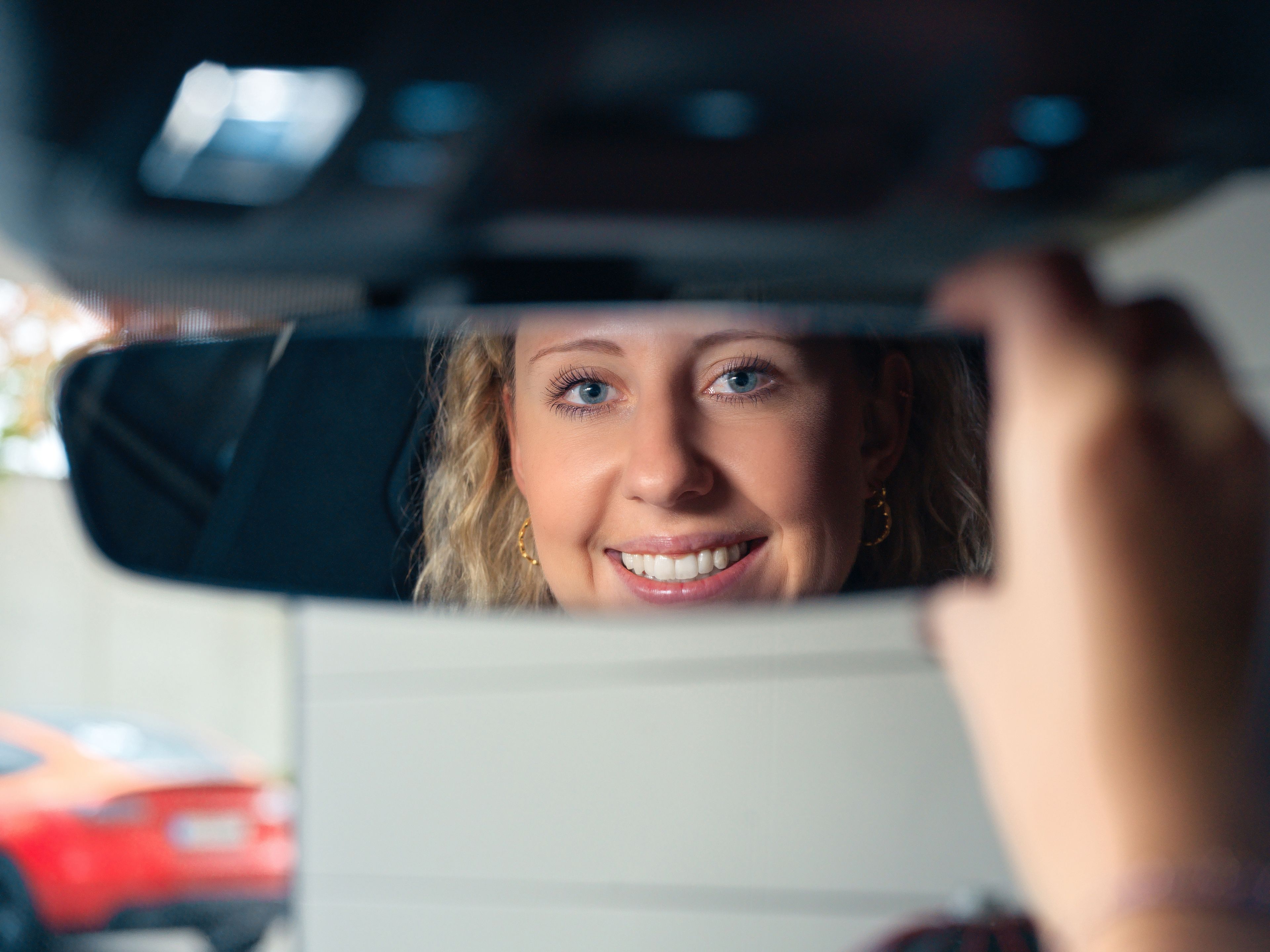 smiling woman in a rearview mirror