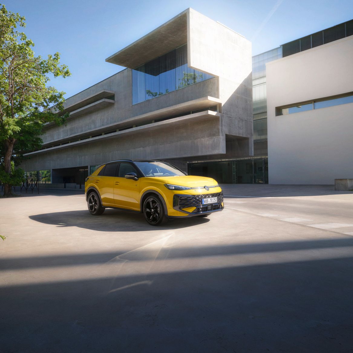 Yellow VW R-Roc outside of a modern building