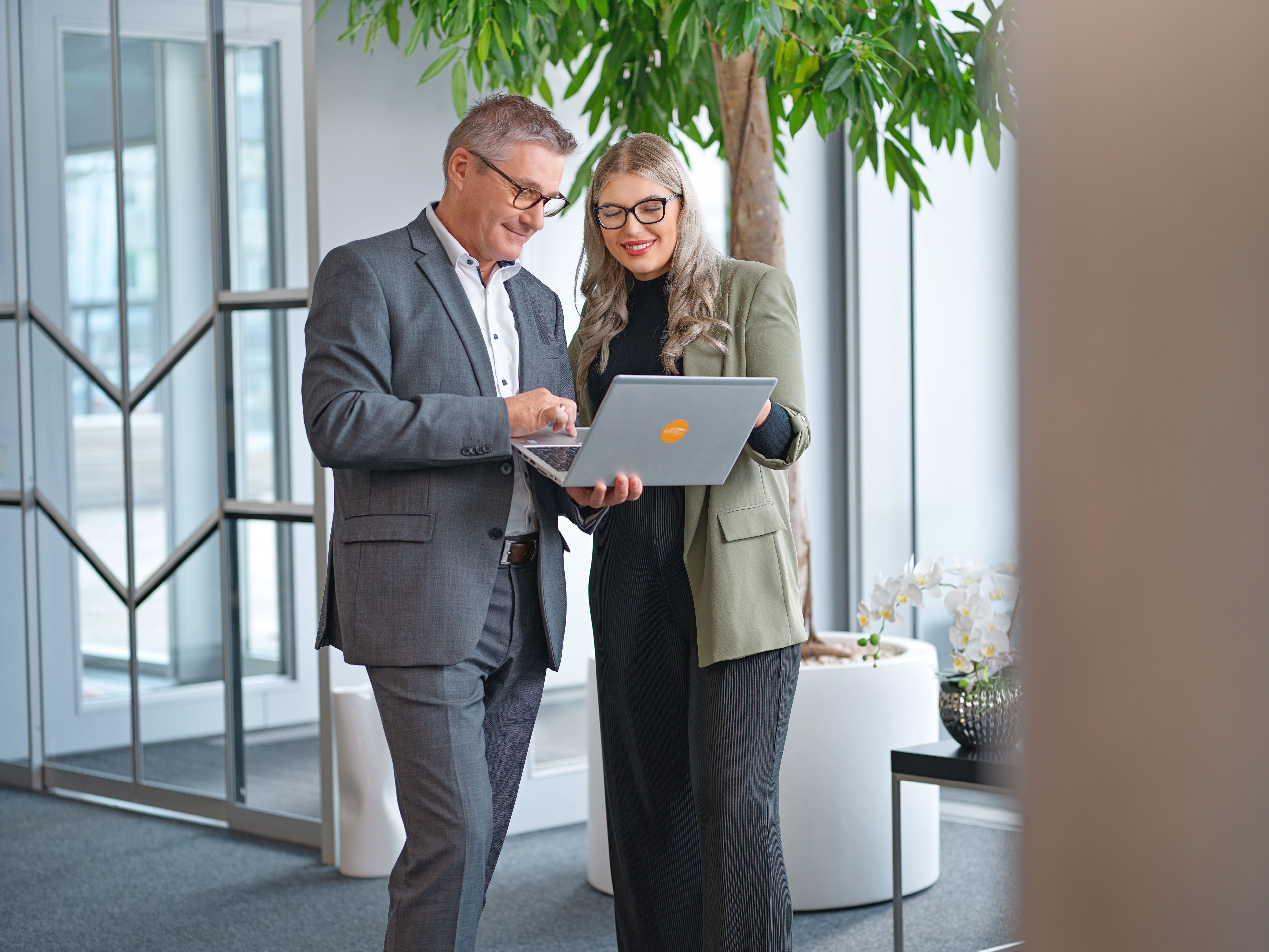 Two people are looking at a laptop.