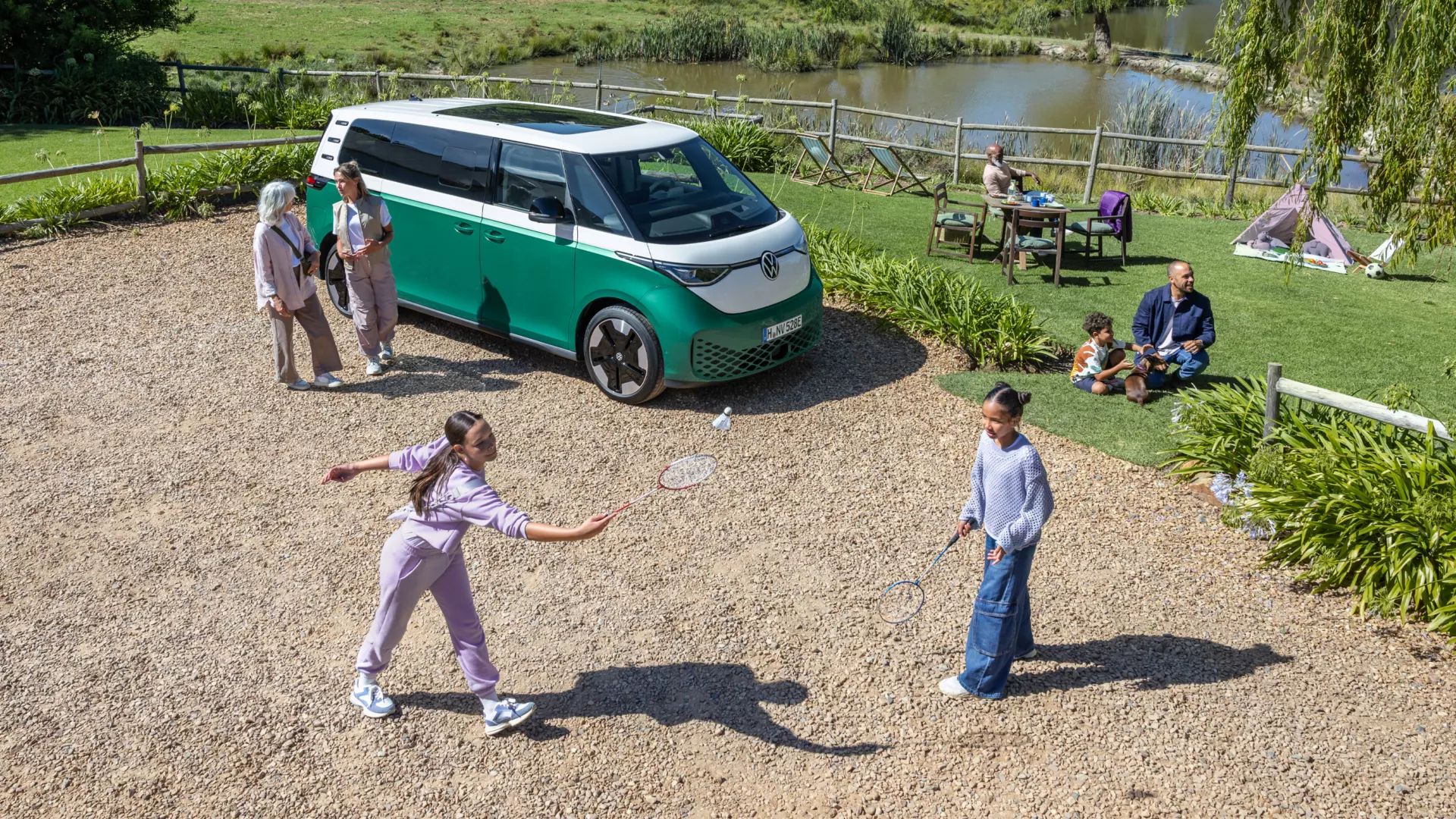 Family playing in a garden around an ID buzz